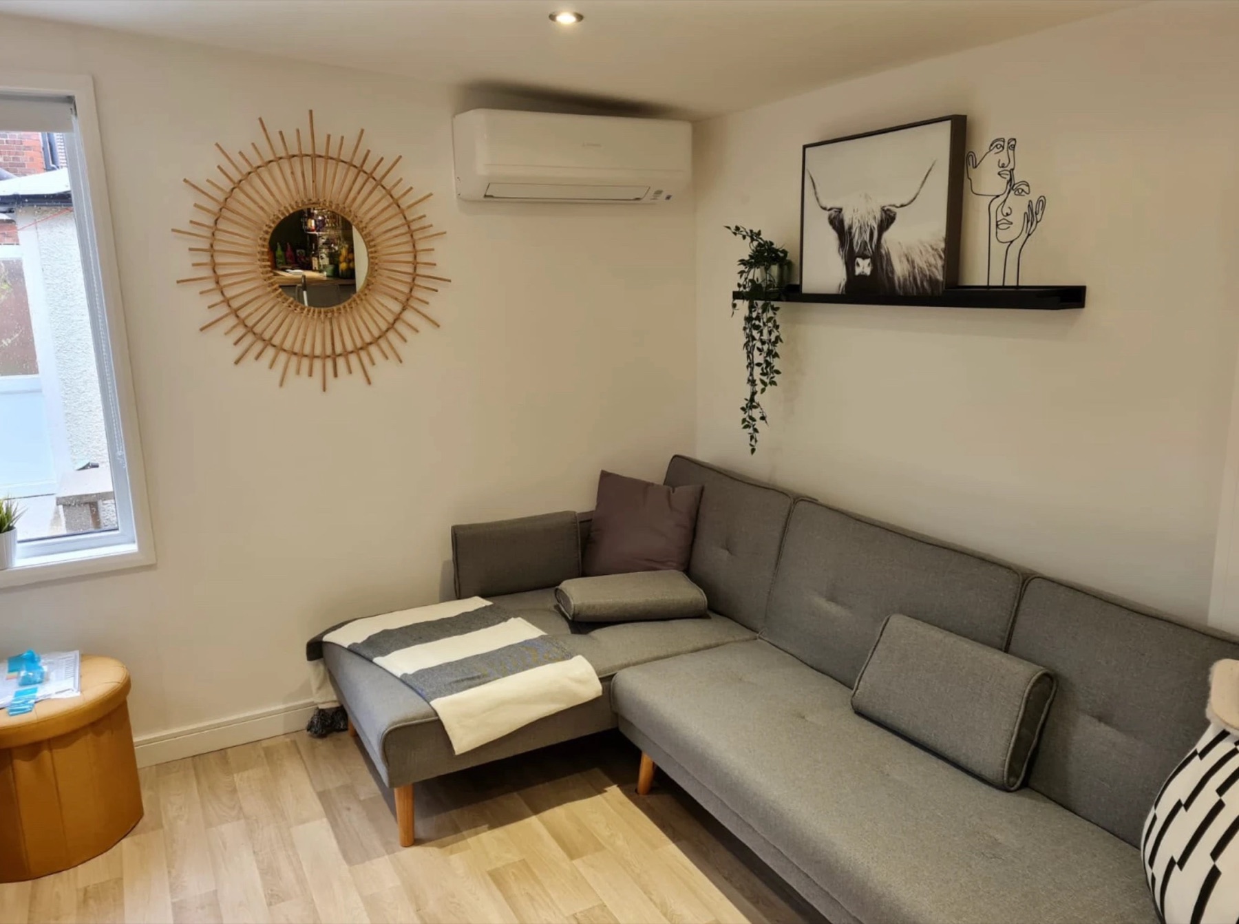 Inside the garden room: wall-mounted air conditioning unit above the sofa